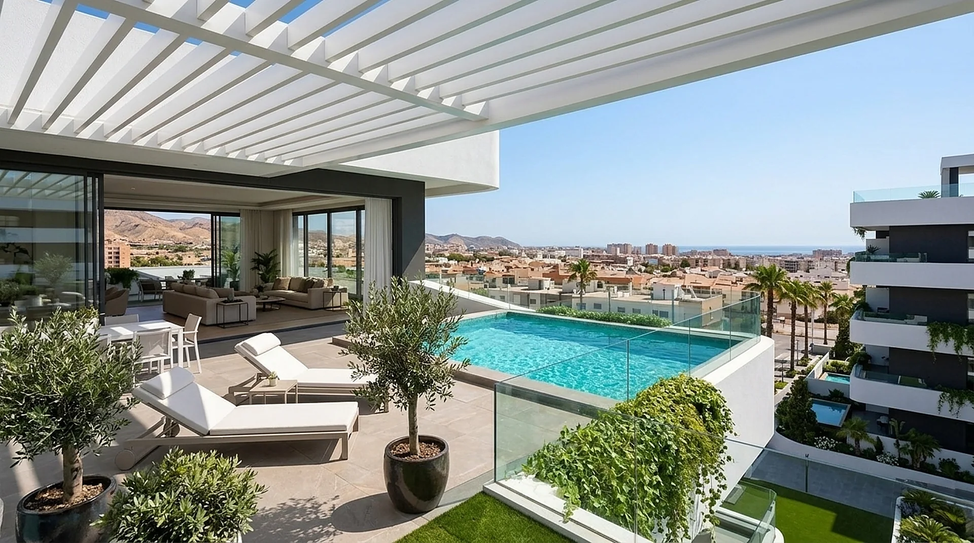 Vista desde la terraza: piscina privada, olivos en maceta y la ciudad con el mar al fondo.