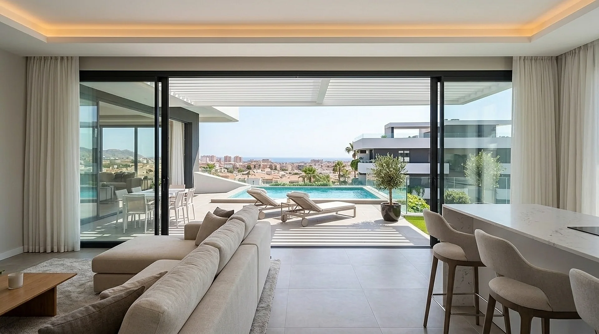 Salón con sofá en L mirando a la terraza y la piscina.