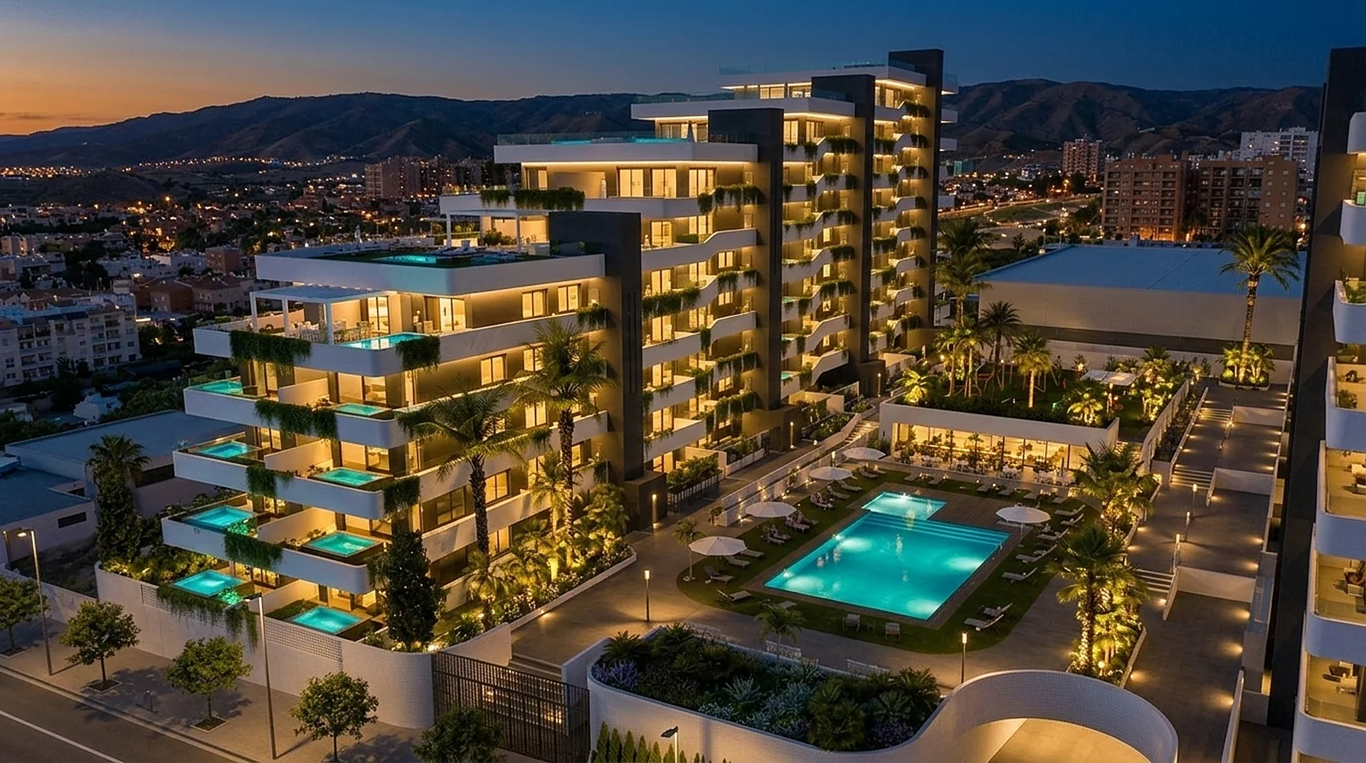 El residencial de noche, con las terrazas y la piscina comunitaria iluminadas.